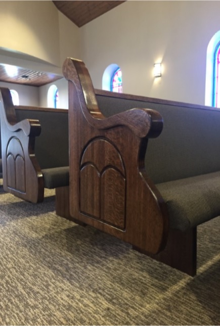 Dark wood engraved church pew ends